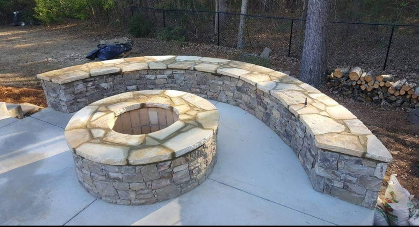 Stone fire pit with curved seating wall
