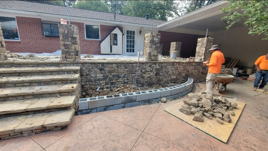 Stacked-stone retaining wall with columns under construction